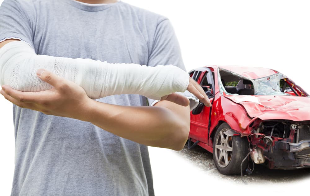 A close-up image features a bandaged arm against the backdrop of a red, wrecked car.