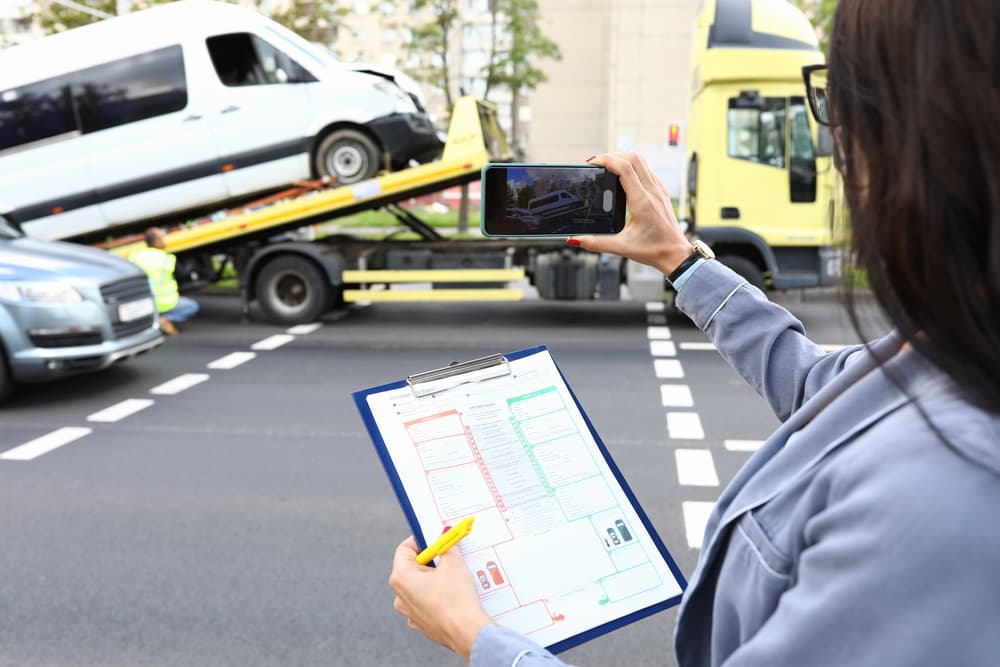 Woman agent records accident for insurance claim following European protocol on smartphone.